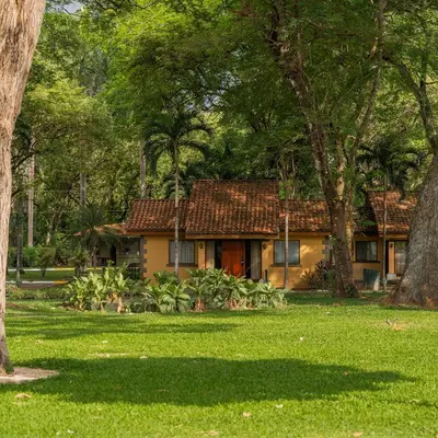 a house in the middle of a yard with trees at CC Beach Front Papagayo All Inclusive in Papagayo, Guanacaste