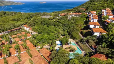 an aerial view of a house with a swimming pool and the ocean at Villas Sol Beach Resort in Playa Hermosa