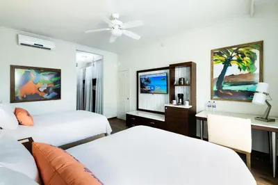 a bedroom with two beds and a desk with a couch at Margaritaville Beach Resort Playa Flamingo in Playa Flamingo