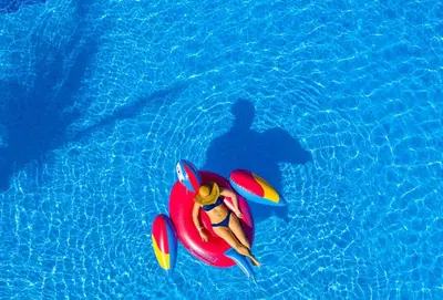 a woman laying on a float in a swimming pool at Margaritaville Beach Resort Playa Flamingo in Playa Flamingo