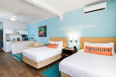 a hotel room with two beds and a kitchen at Margaritaville Beach Resort Playa Flamingo in Playa Flamingo