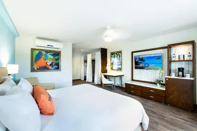 a bedroom with a large white bed and a desk at Margaritaville Beach Resort Playa Flamingo in Playa Flamingo