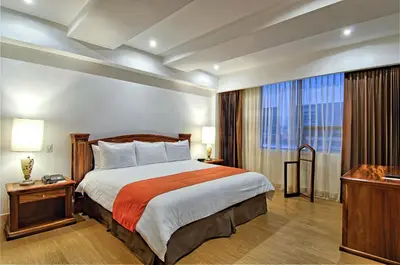 a hotel room with a bed and a large window at Balmoral Hotel San José CR, Historic District in San José