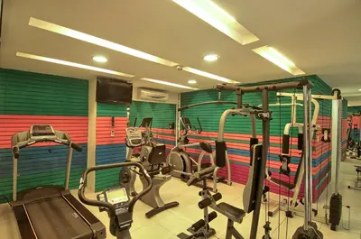 a gym with several cardio machines in a room at Balmoral Hotel San José CR, Historic District in San José