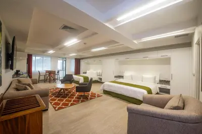 a hotel room with a bed and two chairs at Balmoral Hotel San José CR, Historic District in San José