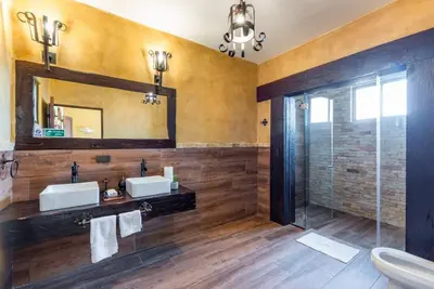 a bathroom with two sinks and a mirror and a shower at Villa El Retiro Luxury Property in Alajuela City