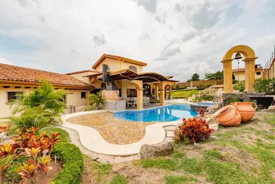 a house with a swimming pool in a yard at Villa El Retiro Luxury Property in Alajuela City