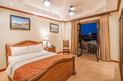 a bedroom with a bed and a large window at Hotel Casa Roland San Jose in San José