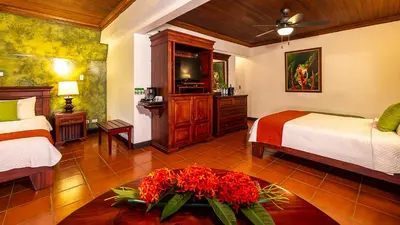 a bedroom with two beds and a tv in it at Tilajari Hotel Resort in Fortuna