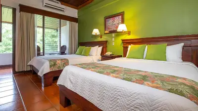 a hotel room with two beds and green walls at Tilajari Hotel Resort in Fortuna