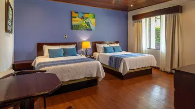 a bedroom with two beds with blue walls at Tilajari Hotel Resort in Fortuna