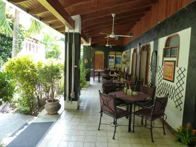a restaurant with tables and chairs on a patio at Hotel Villa Romantica in Manuel Antonio