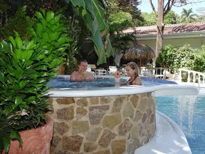 a man and a woman in a swimming pool at Hotel Villa Romantica in Manuel Antonio