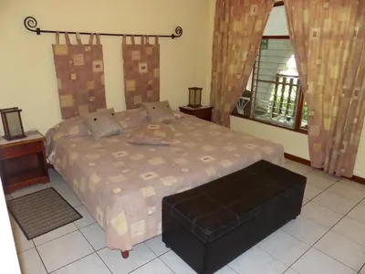 a bedroom with a bed and a large window at Hotel Villa Romantica in Manuel Antonio