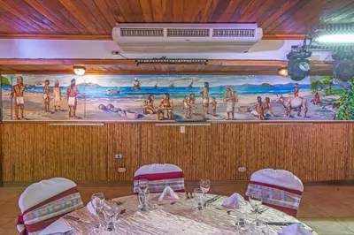 a large painting on the wall in a room with a table at Hotel Villas Lirio in Manuel Antonio
