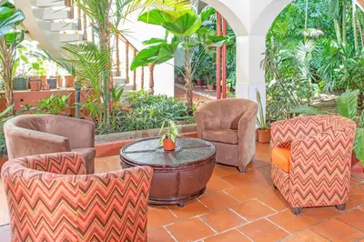 a patio with two chairs and a table at Hotel Villas Lirio in Manuel Antonio