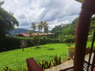 a view of a green field with a house at Hospedaje Luis & Ana in Pejibaye