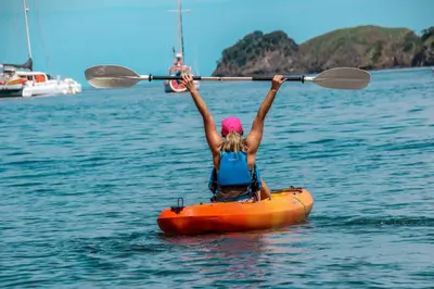 a woman in an orange kayak in the water at Hotel Bosque del Mar Playa Hermosa in Playa Hermosa