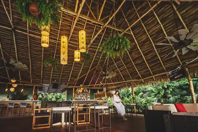 a woman standing in a restaurant with tables and chairs at Bahia del Sol Beach front Boutique Hotel in Potrero
