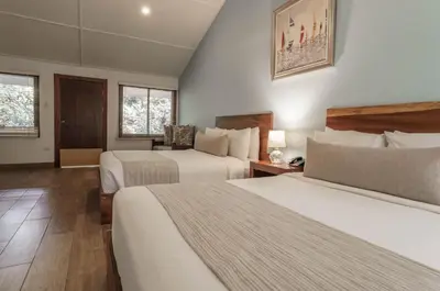 a hotel room with two beds and two windows at Bahia del Sol Beach front Boutique Hotel in Potrero
