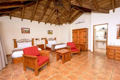 a room with two beds and red chairs at Borinquen Thermal Resort in Liberia