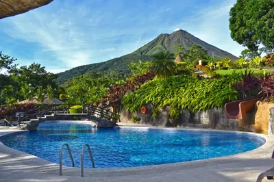 a pool at a resort with a mountain in the background at Hotel Los Lagos Spa & Resort in Fortuna