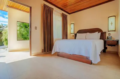 a bedroom with a bed and a large window at Hotel Los Lagos Spa & Resort in Fortuna