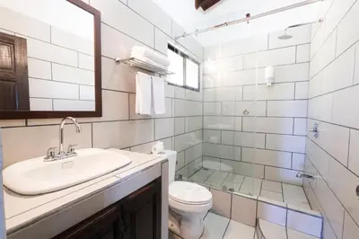 a bathroom with a sink and a toilet and a mirror at Hotel Terraza del Pacifico in Jacó
