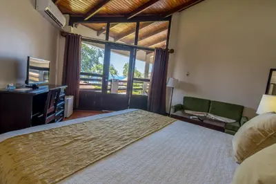 a bedroom with a large bed and a large window at Hotel Terraza del Pacifico in Jacó