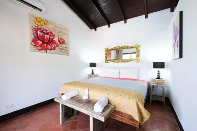 a bedroom with a bed with a table and a mirror at Hotel Terraza del Pacifico in Jacó