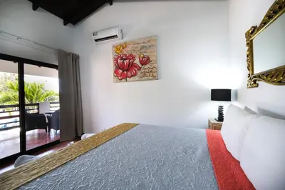 a bedroom with a bed and a view of a balcony at Hotel Terraza del Pacifico in Jacó