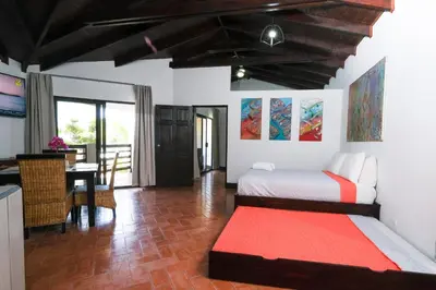 a bedroom with a bed and a dining room at Hotel Terraza del Pacifico in Jacó