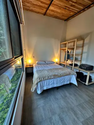 a bedroom with two beds and a large window at Moon Forest Apartments in Monteverde Costa Rica