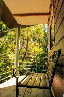 a bench sitting on the porch of a house at Moon Forest Apartments in Monteverde Costa Rica