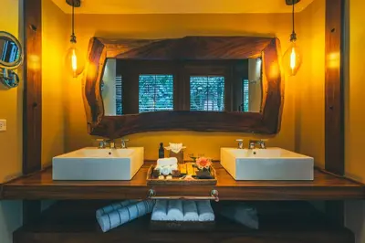 a bathroom with two sinks and a mirror at Amor Arenal Adults Friendly in Fortuna