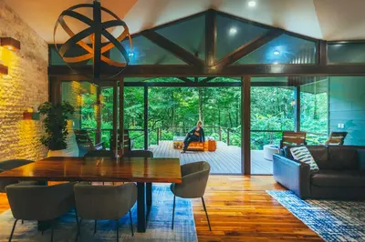 a living room with a table and a person sitting on a couch at El Silencio Lodge & Spa Costa Rica in Toro Amarillo