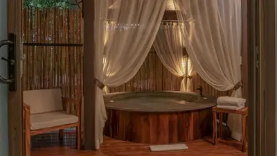 a bath tub in a room with a chair at El Silencio Lodge & Spa Costa Rica in Toro Amarillo