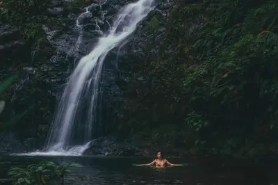 a man in the water in front of a waterfall at El Silencio Lodge & Spa Costa Rica in Toro Amarillo