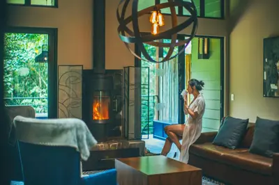 a woman talking on a cell phone in a living room at El Silencio Lodge & Spa Costa Rica in Toro Amarillo