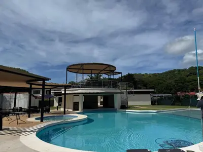 a large swimming pool with a building with a dome at Nacazcol Hotel y Villas in Coco