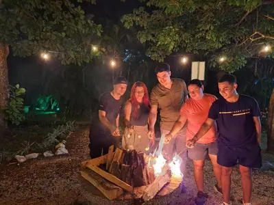 a group of people standing around a bonfire at Nacazcol Hotel y Villas in Coco