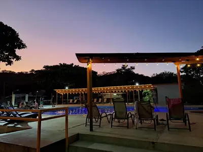 a group of chairs under a pavilion at night at Nacazcol Hotel y Villas in Coco