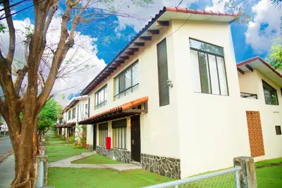 a white house with a fence in front of it at Nacazcol Hotel y Villas in Coco