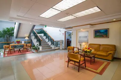 a living room with a couch and a table and chairs at Apartotel & Suites Villas del Rio in San José
