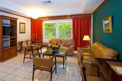 a living room with a couch and a table at Apartotel & Suites Villas del Rio in San José