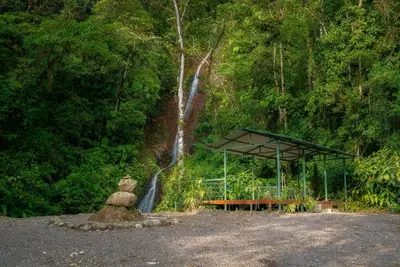 a stone statue sitting in front of a waterfall at Hotel Quelitales in Cachí