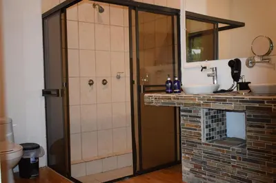 a bathroom with a shower and a sink at Hotel Quelitales in Cachí
