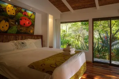 a bedroom with a bed and a large window at Hotel Quelitales in Cachí