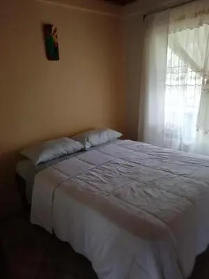 a bedroom with a large white bed with a window at Casas de Campo Las Pavitas Cottages 