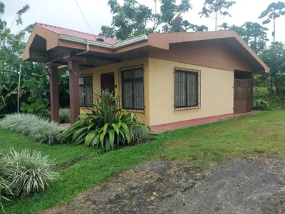a small house with a green lawn in front of it at Casas de Campo Las Pavitas Cottages 